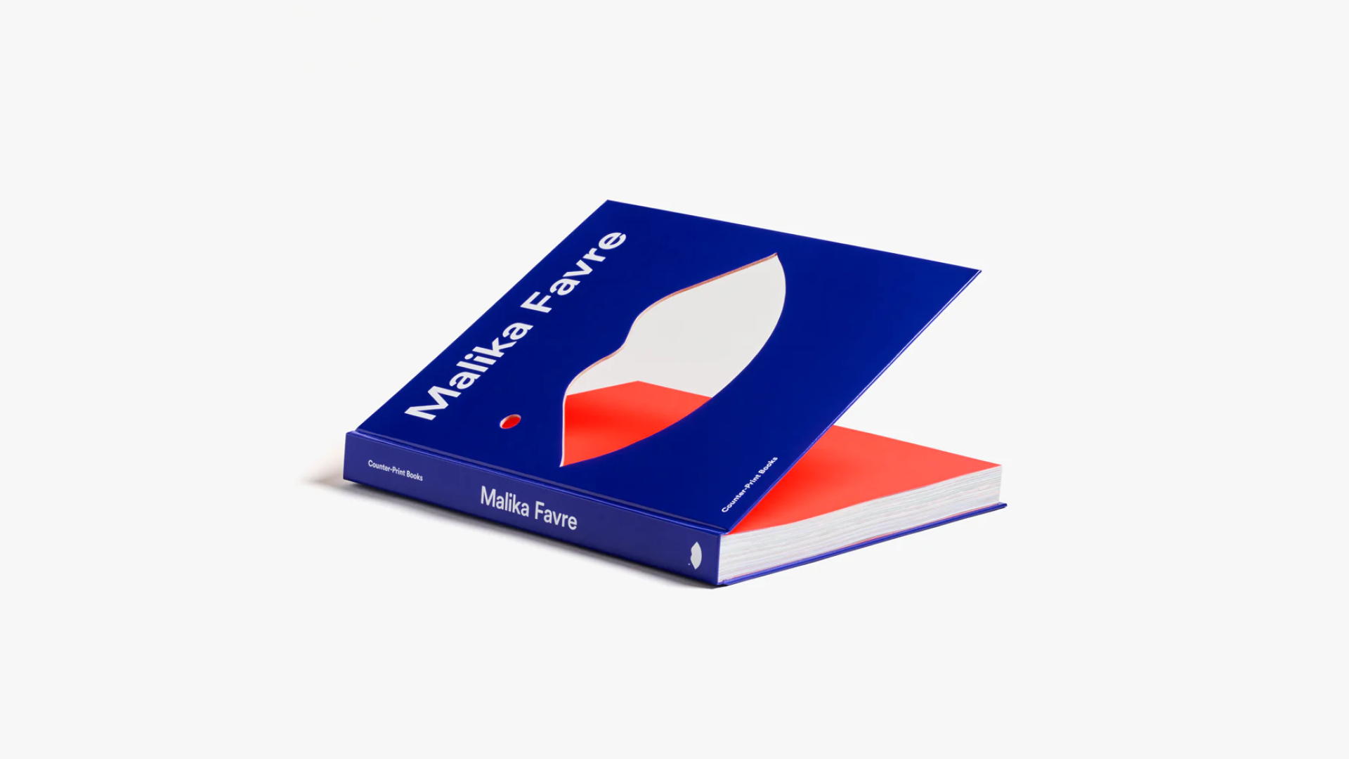 A coffee table book with a bold indigo cover and the shape of lips cutout from the middle