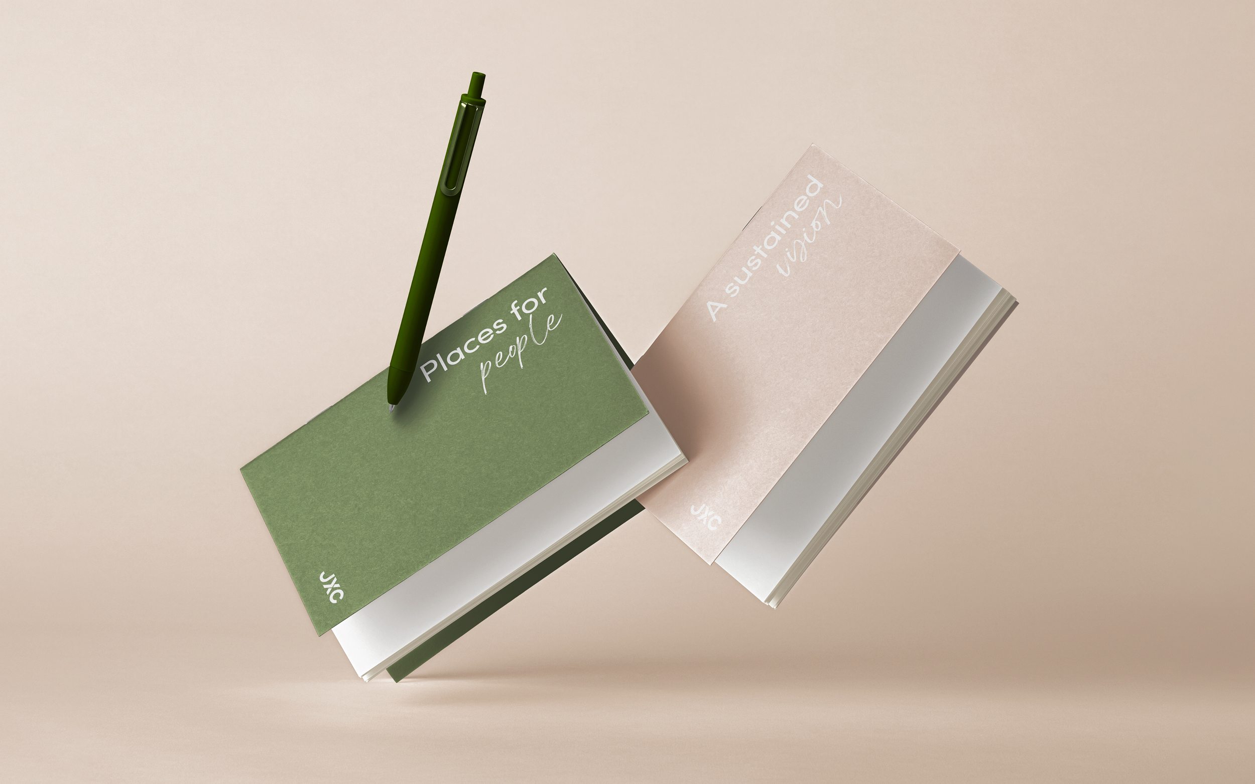 mock up of JXC branded notebooks in blush and forest green