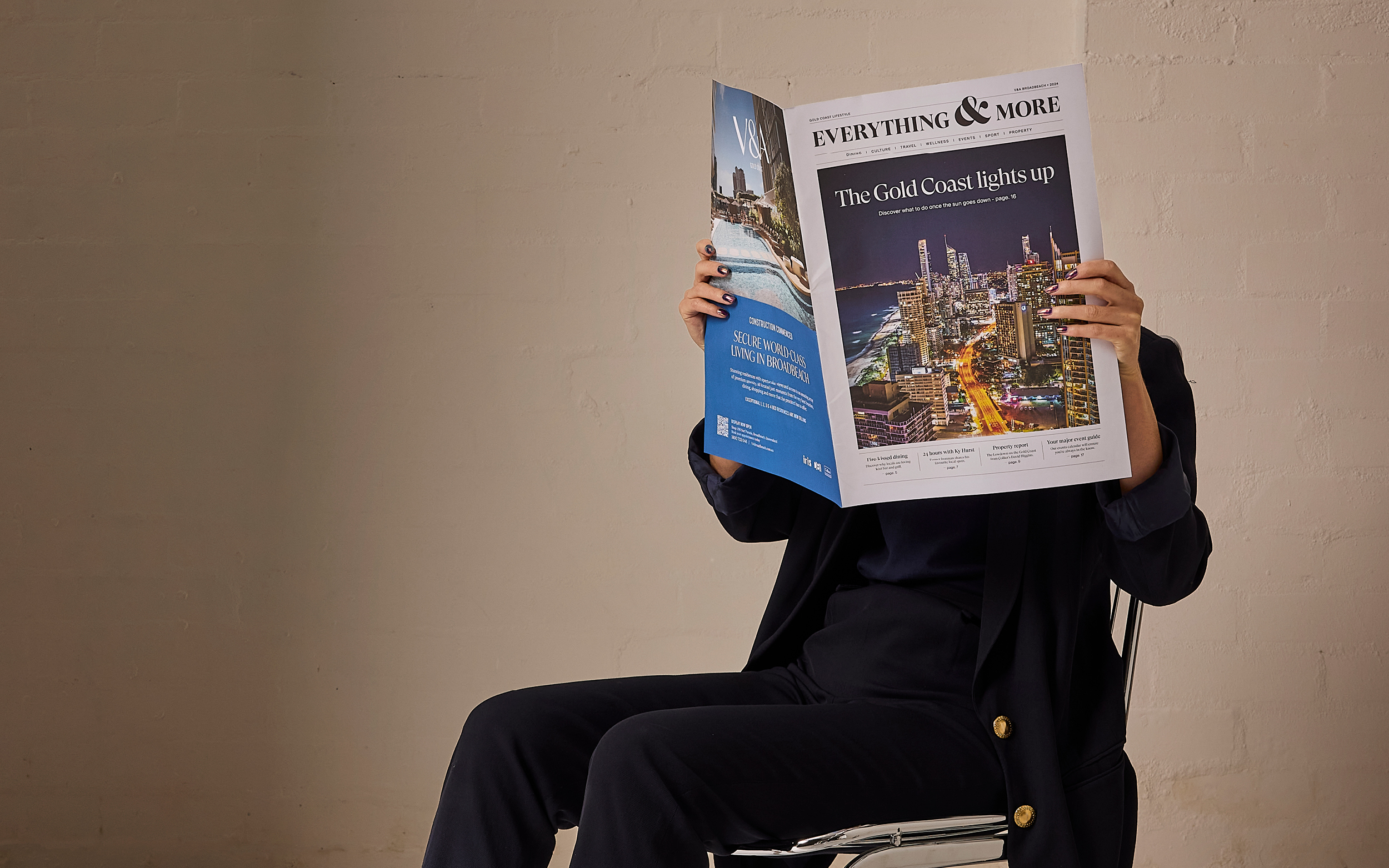 Woman sitting on chair reading V&A broadsheet